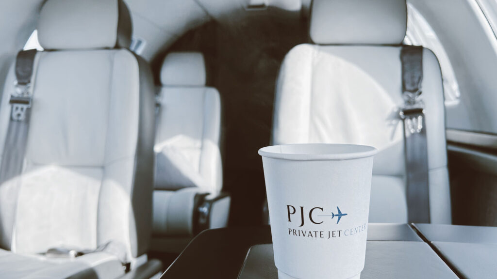coffee cup branded private jet center inside of private jet on table