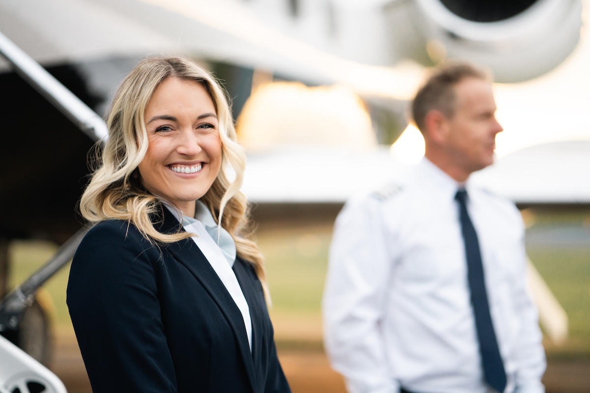 flight attendant and pilot outside private jet