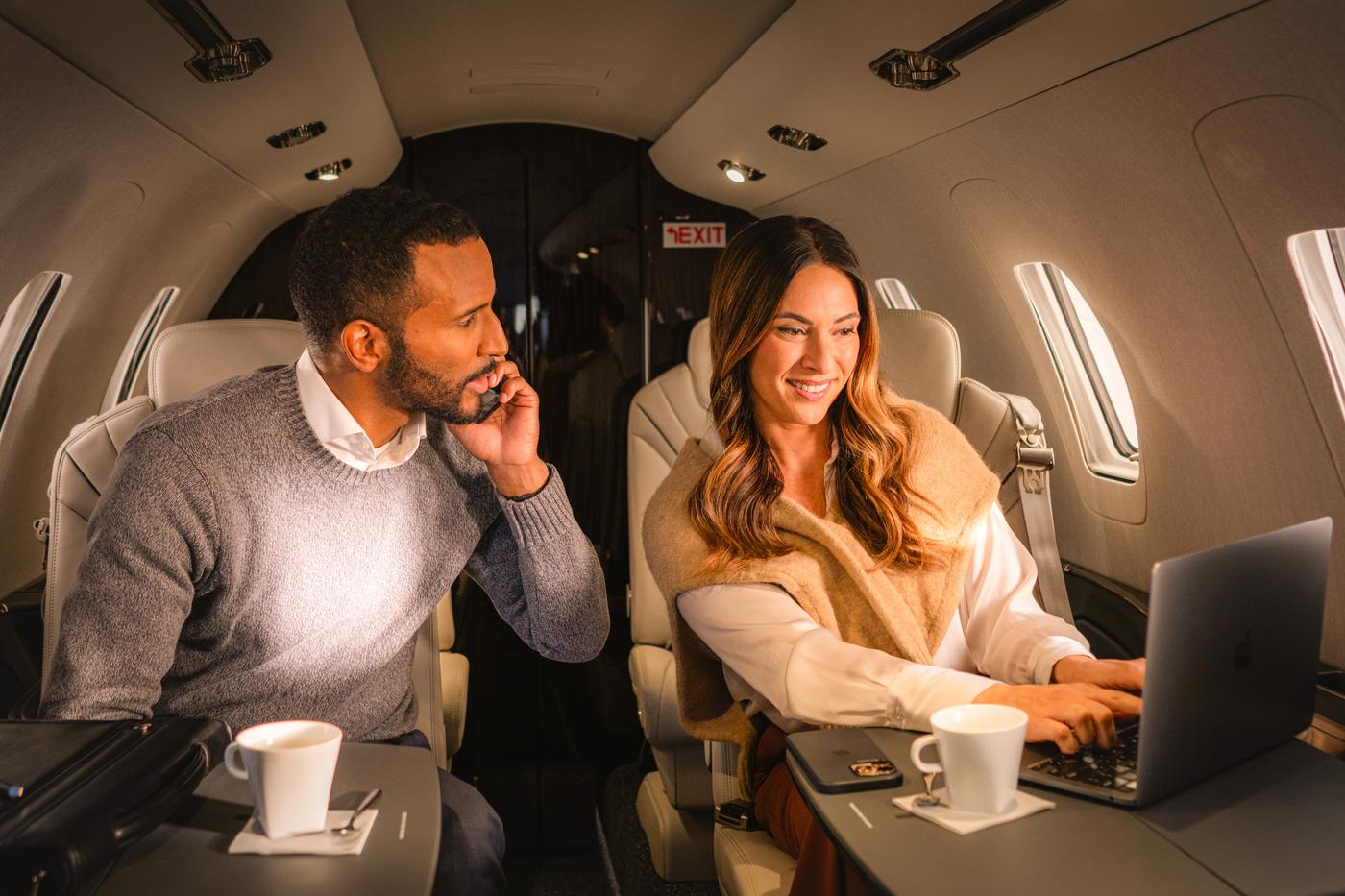 Two passengers working in a Private Jet Center cabin